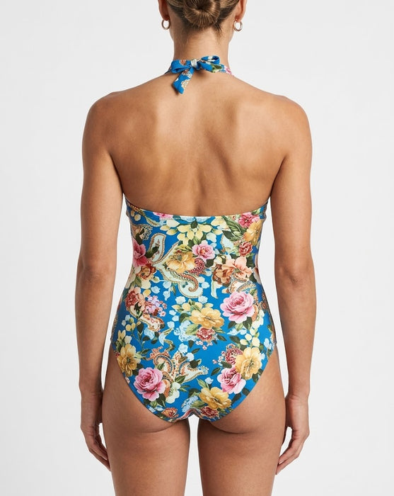 Woman wearing a floral high-waisted swimsuit on a plain background