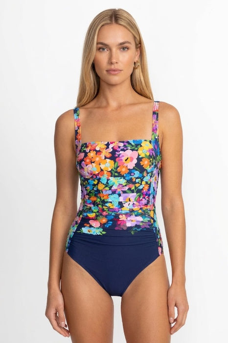 Woman wearing a colorful floral one piece swimsuit with navy bottom from Johnny Was