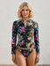 Woman wearing a matching black long sleeve surf shirt and hipster bikini bottom with colorful floral from Johnny Was