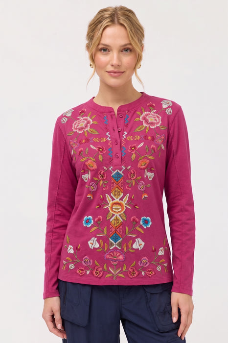 Woman wearing a pink embroidered long-sleeve top with henley neckline and raw seams from Johnny Was