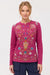 Woman wearing a pink embroidered long-sleeve top with henley neckline and raw seams from Johnny Was