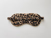 A leopard print sleep mask with a ruffled elastic strap, displayed flat against a clean white background.