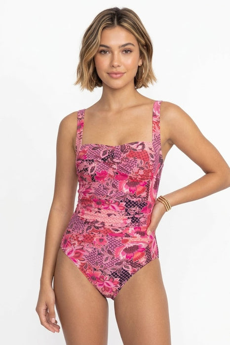 Woman wearing a pink floral swimsuit on a white background