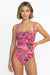 Woman wearing a pink floral swimsuit on a white background