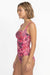 Woman wearing a pink floral swimsuit on a white background
