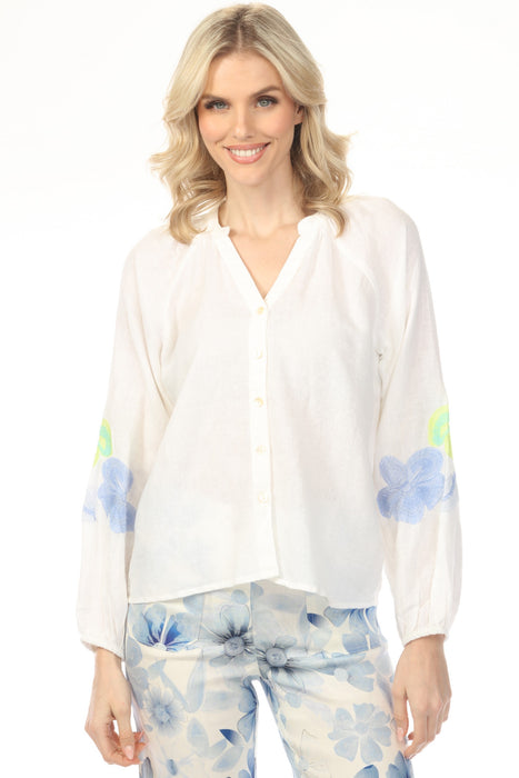 Woman wearing white button front v-neck blouse with floral embroidered raglan sleeves from Charlie B