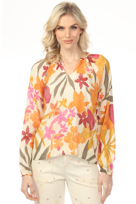 Woman wearing a colorful floral v-neck blouse with long raglan sleeves from Charlie B