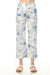 Woman wearing white cropped wide leg pants with blue floral print from Charlie B