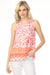 Woman wearing a sleeveless patterned top with v-neck and ruffled collar from Charlie B