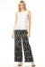 Woman wearing black wide-leg pants with white diamond pattern from Charlie B