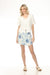 Woman wearing a white wrap skort with blue floral pattern from Charlie B