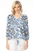 Woman wearing a blue and white ikat patterned v-neck blouse from Charlie B