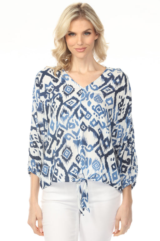 Woman wearing a blue and white ikat patterned v-neck blouse from Charlie B