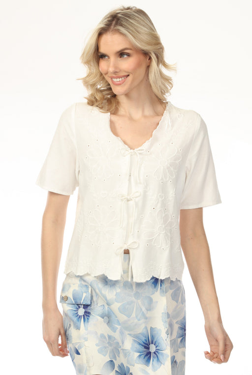 Woman wearing white floral embroidered cover-up with eyelets and front ties from Charlie B