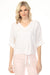 Woman wearing a white v-neck blouse with a front tie detail and roll-up sleeves from Charlie B
