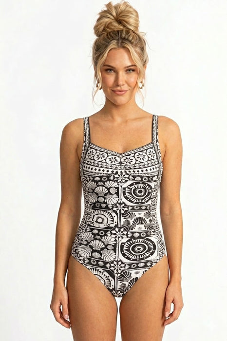 Woman wearing a black and white patterned one-piece swimsuit with sweetheart neck from Johnny Was