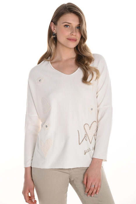 Woman wearing a white long-sleeve pullover knit top with decorative elements and v-neck from Frank Lyman