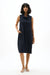 Woman wearing a sleeveless funnel collar trapeze dress with front pockets in a relaxed cocoon silhouette for a modern minimalist look