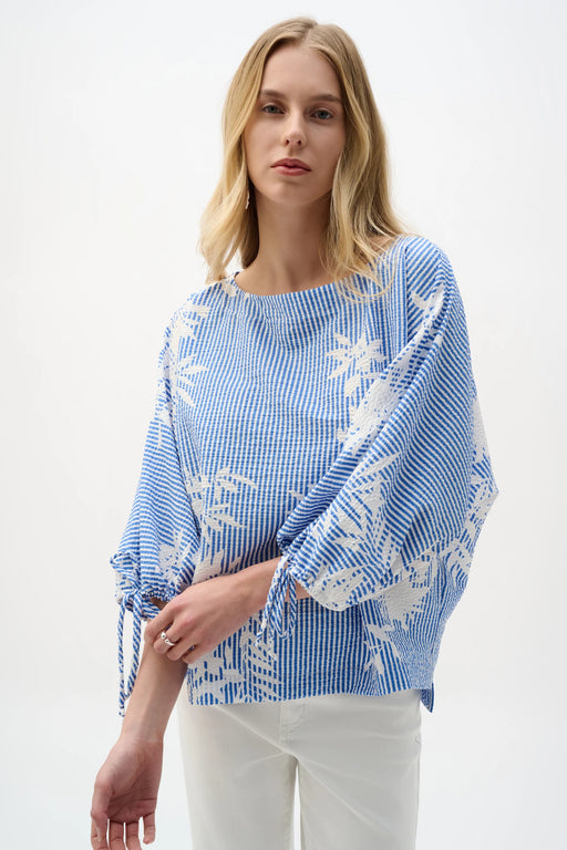 Woman wearing Joseph Ribkoff vanilla and blue floral print trapeze top styled for resort wear, brunch, casual outings, and bohemian chic summer fashion.