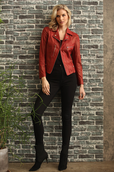 Woman wearing a red vegan leather moto jacket with zipper trim and grommet accent from Insight New York