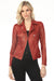 Woman wearing a red vegan leather moto jacket with zipper trim and grommet accent from Insight New York