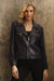 Woman wearing dark blue vegan leather moto jacket with zip-up front from Insight New York