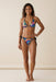 Woman wearing a matching colorful printed triangle bikini top and bottom with black trim on the edges from Johnny Was