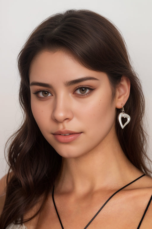 Woman wearing a silver-tone heart-shaped earring from Johnny Was