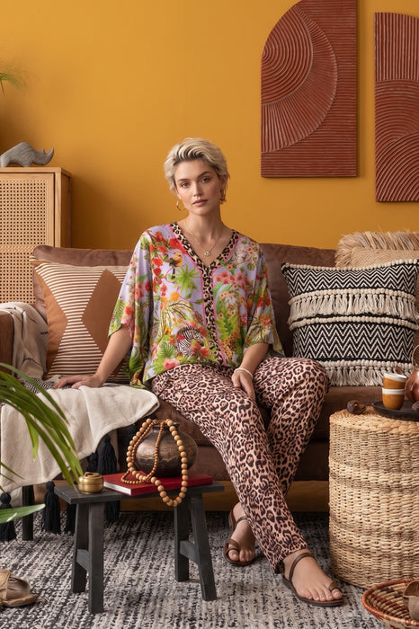 Woman wearing a colorful floral and leopard print top with v-neck and 3/4 sleeves from Johnny Was