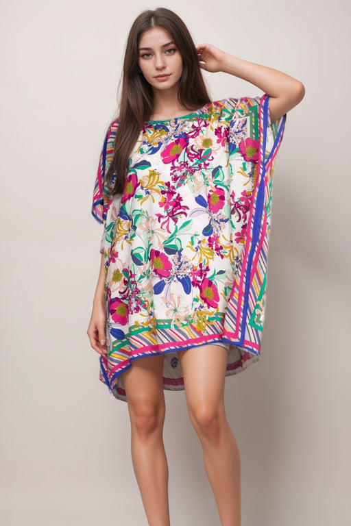 Woman wearing a colorful floral and striped short kaftan dress with boat neck from Johnny Was