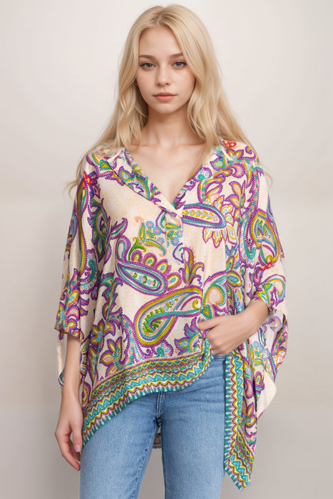 Woman wearing a colorful silk poncho top with paisley print and henley neckline from Johnny Was
