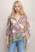 Woman wearing a colorful silk poncho top with paisley print and henley neckline from Johnny Was