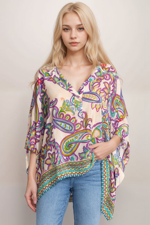 Woman wearing a colorful silk poncho top with paisley print and henley neckline from Johnny Was