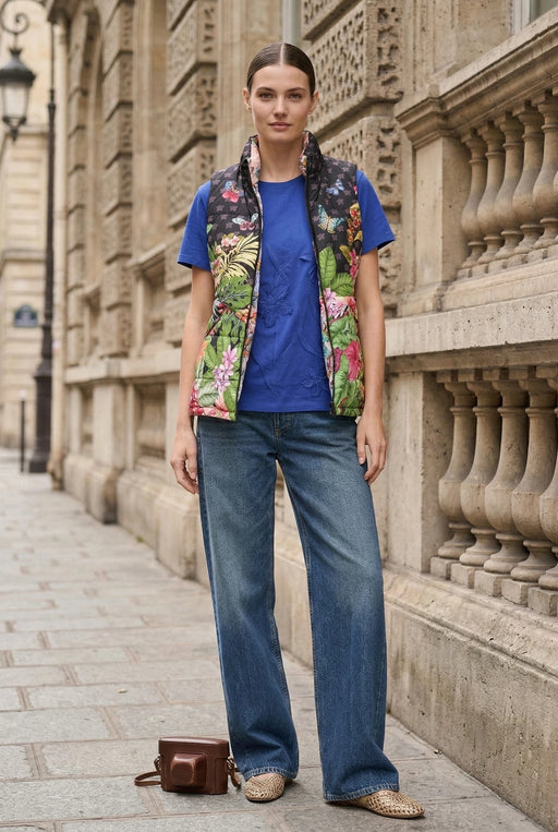 Woman wearing a tropical printed puffer vest with zip up front and pockets from Johnny Was