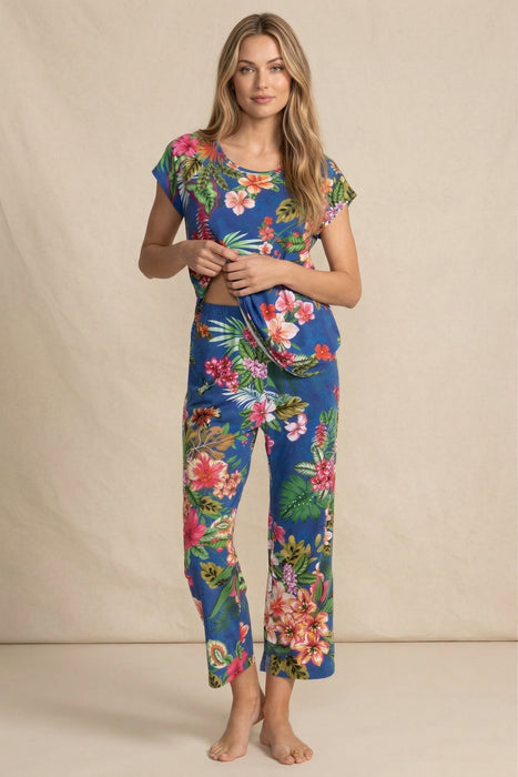 Woman wearing a matching blue floral sleepwear including a short sleeve top and crop pajama pants from Johnny Was