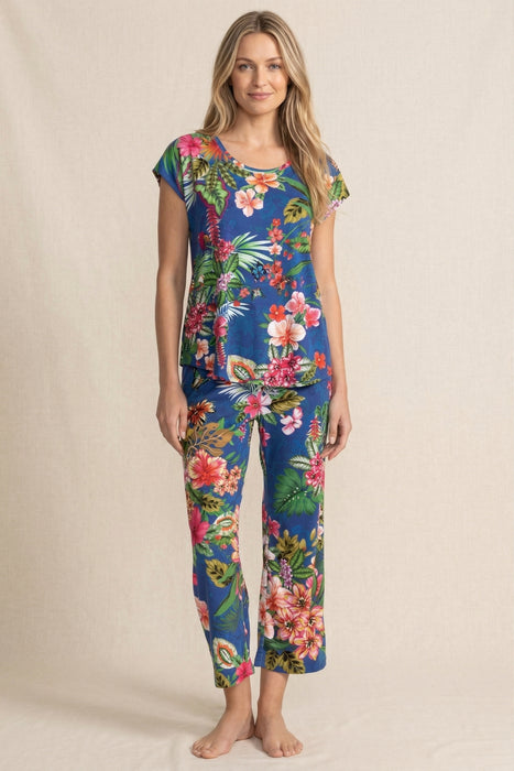 Woman wearing a matching blue floral sleepwear including a short sleeve top and crop pajama pants from Johnny Was