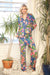 Woman wearing a colorful floral pajama set from Johnny Was