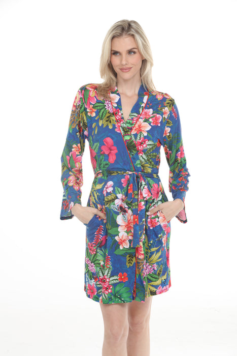Woman wearing a blue long sleeve sleep robe with colorful tropical floral print, waist tie and side pockets from Johnny Was