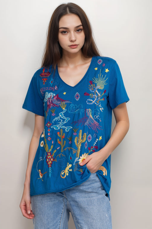 Woman wearing a blue Arizona-inspired embroidered t-shirt with v-neck and short sleeves from Johnny Was