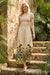Woman wearing a cream-colored wide leg pants with floral print and drawstring waistband from Johnny Was