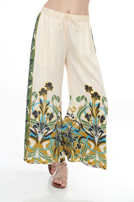 Woman wearing a cream-colored wide leg pants with floral print and drawstring waistband from Johnny Was