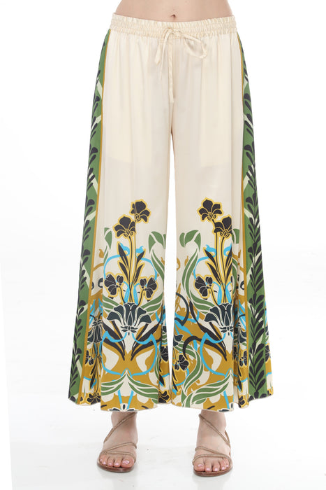 Woman wearing a cream-colored wide leg pants with floral print and drawstring waistband from Johnny Was