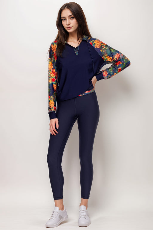 Woman wearing a navy activewear legging with floral waistband from Johnny Was