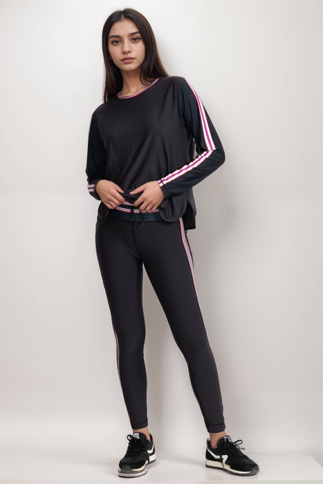 Woman wearing a black activewear legging with waist and side stripes from Johnny Was