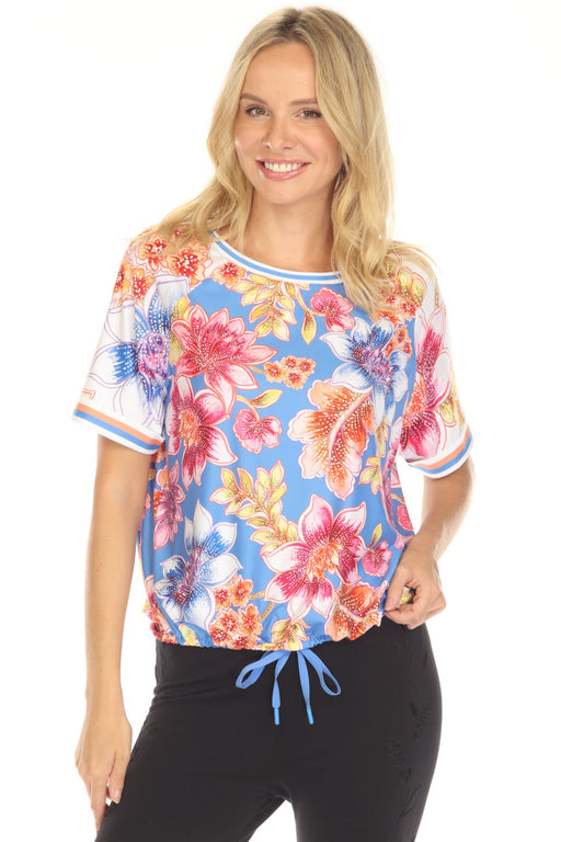 Woman wearing a colorful floral activewear top with drawstring hem from Johnny Was
