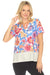 Woman wearing a colorful floral activewear top with a white bottom section from Johnny Was