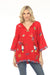 Woman wearing a red embroidered tunic top with beaded tassel tie v-neck from Johnny Was