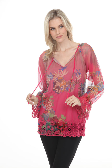 Woman wearing a pink printed mesh top with lace trim and split v-neck with tie from Johnny Was