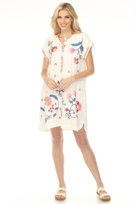 Woman wearing a white floral embroidered dress with side pockets from Johnny Was
