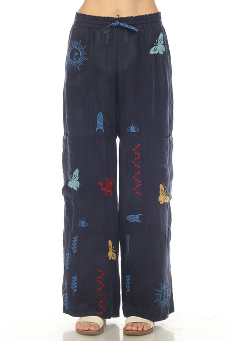 Woman wearing a navy blue embroidered wide leg pant with drawstring elastic waistband from Johnny Was